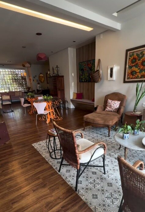 Ambiente de espera do escritório, com poltronas, tapete e quadros